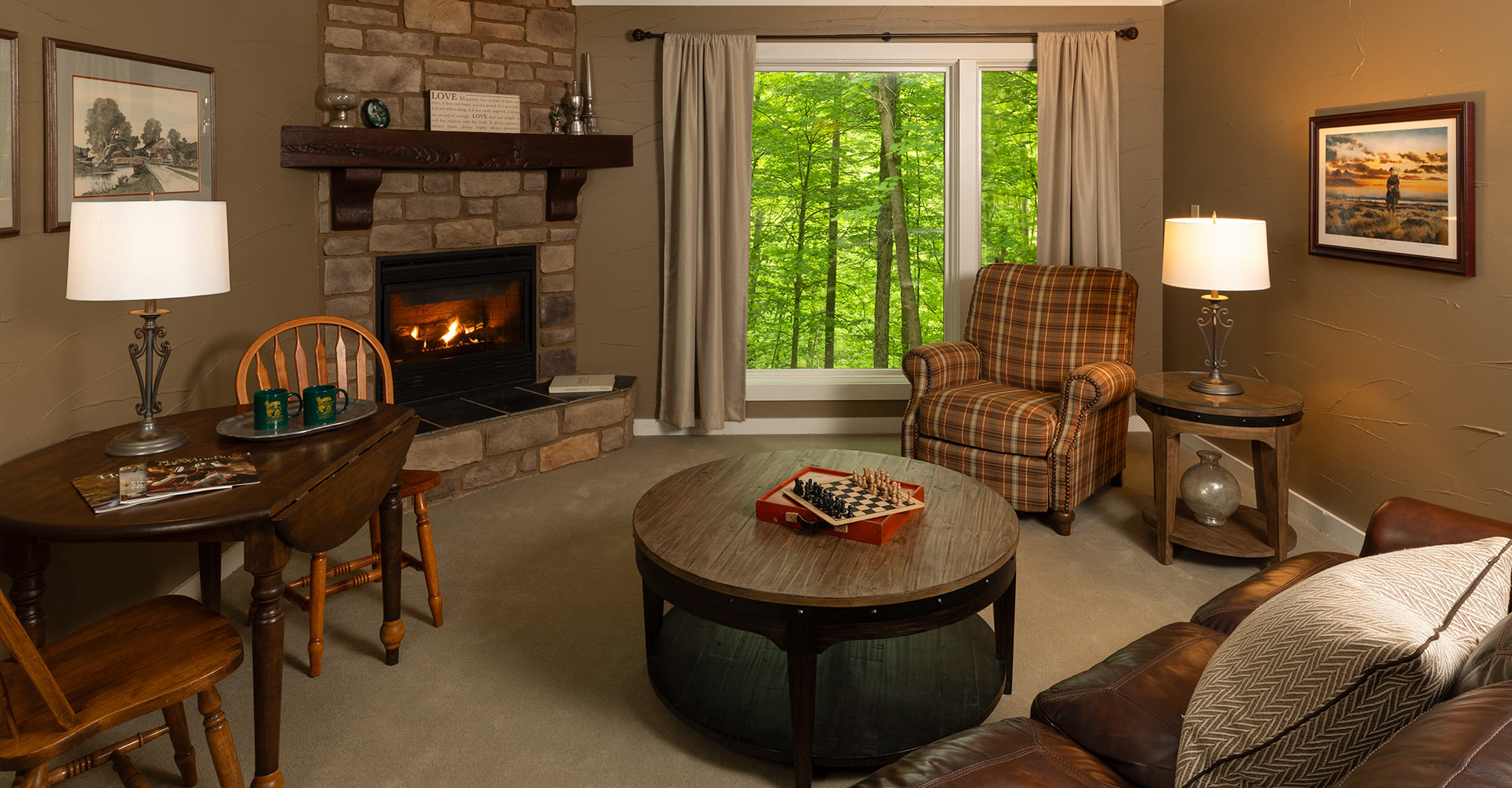 Interior of a room, with a chair, table, fireplace, couch, and game.