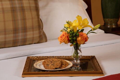 Cookies and a vase of flowers on a tray.