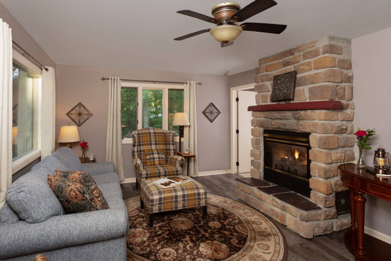 Fireplace, chair, and couch in the Drummond cabin at Glenlaurel.