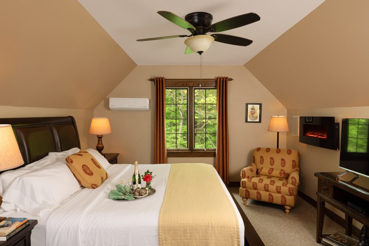 Picture of the bed in the Robertson Garret Room at Glenlaurel, with champagne and chocolate covered strawberries.