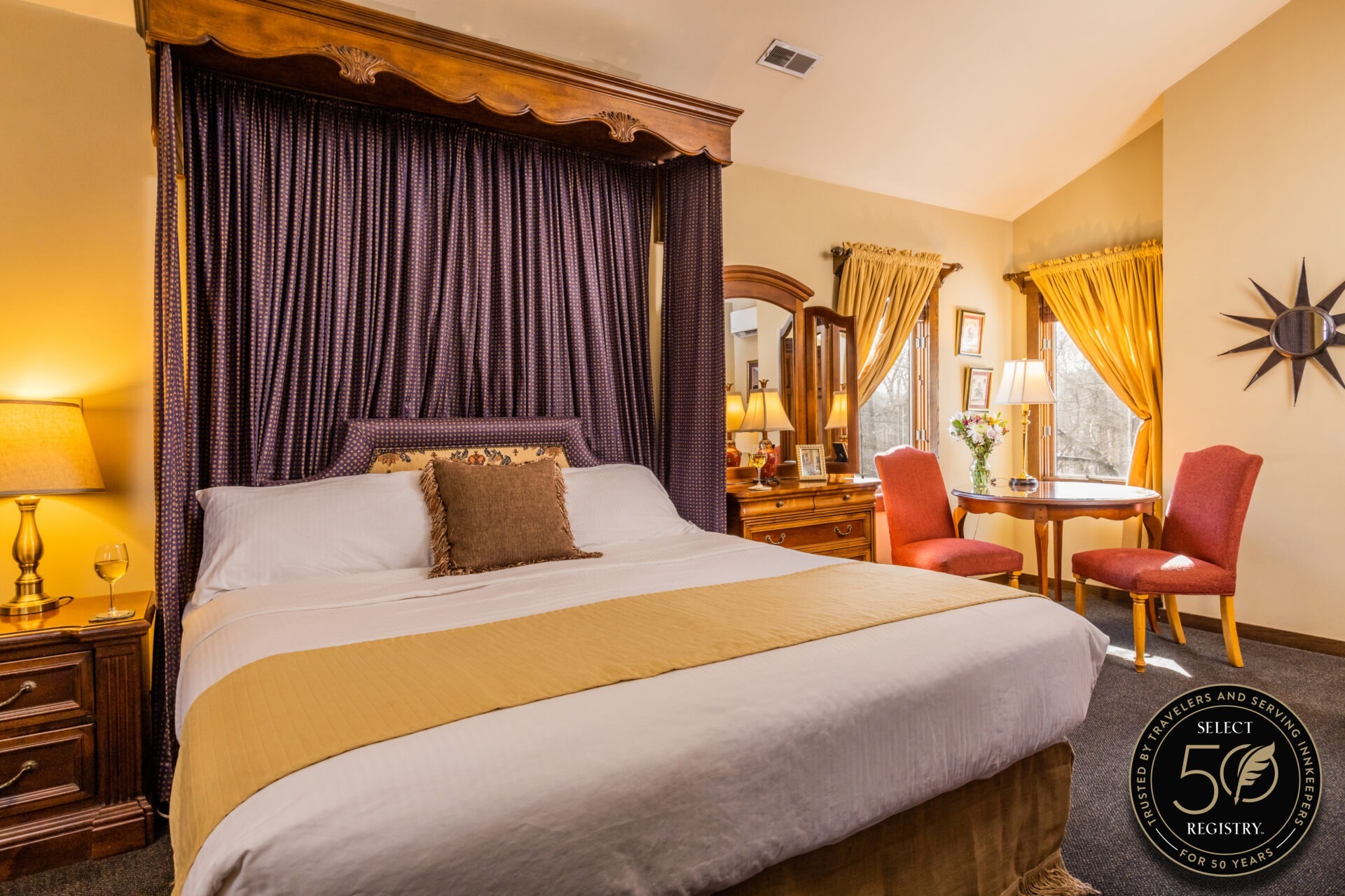 Photo of bed in a room at Glenlaurel, a Scottish Inn and Cottages. Select Registry Distinguished Inns of North America logo in bottom right corner.