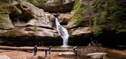 People hiking near a waterfall.