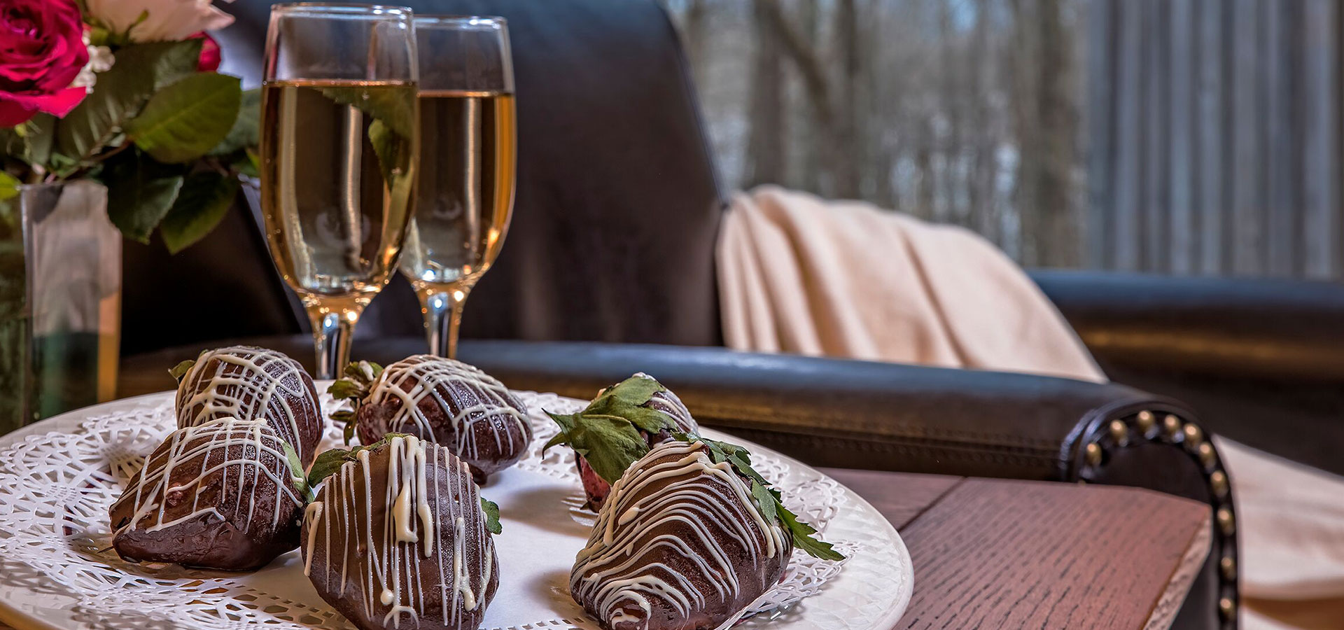 Two glasses of white wine and chocolate covered strawberries.