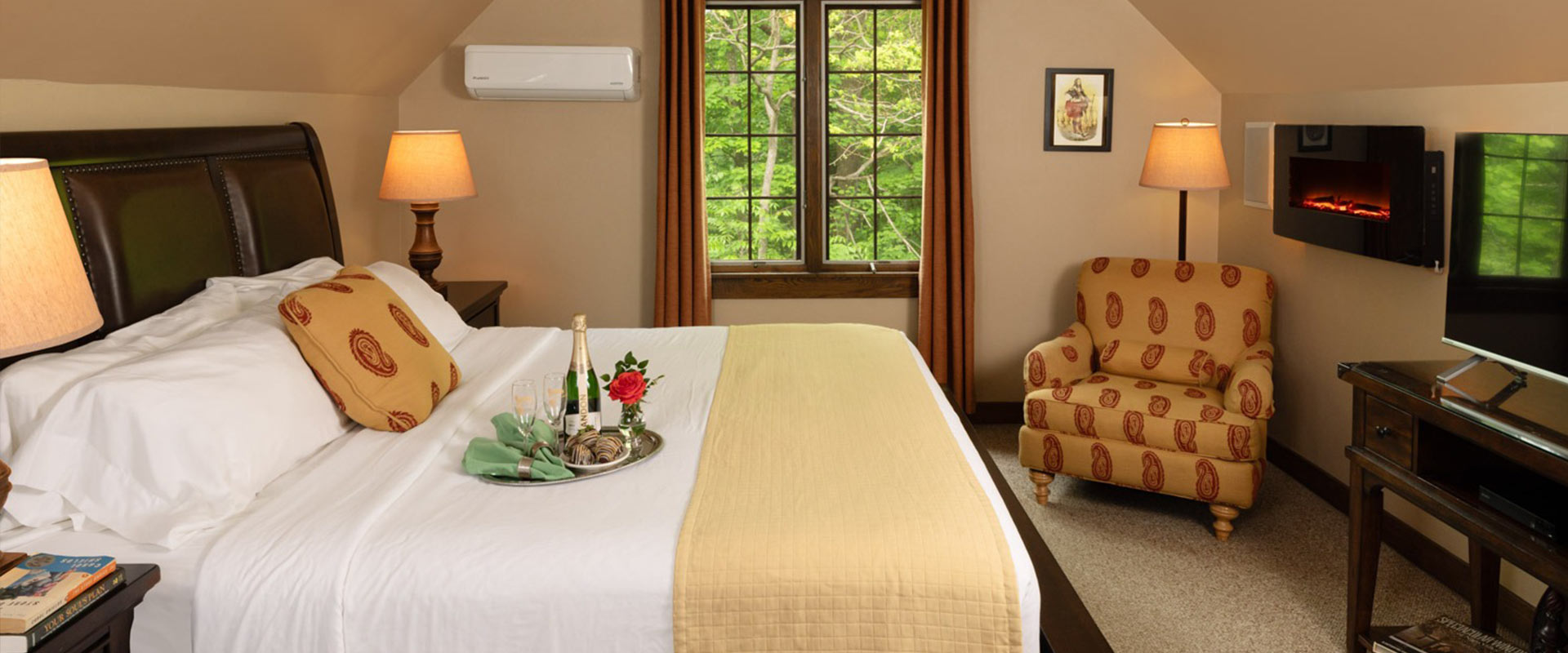 Picture of the bed in the Robertson Garret Room at Glenlaurel, with champagne and chocolate covered strawberries.