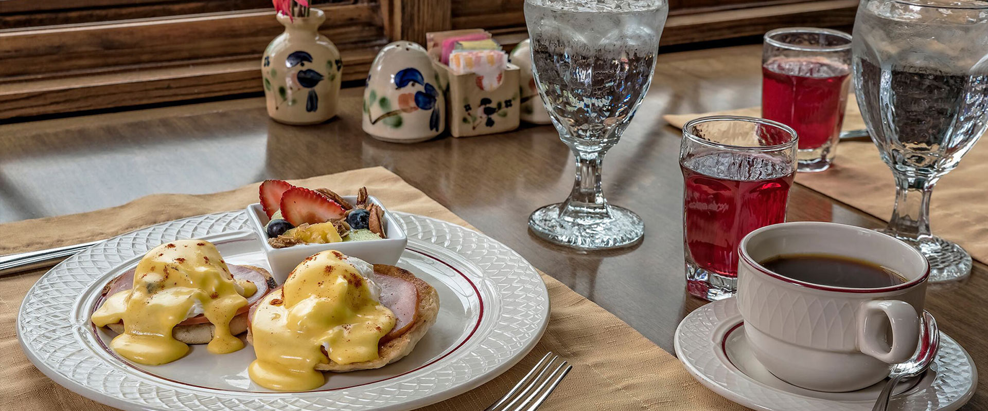 Eggs benedict, water, juice, and coffee for breakfast.