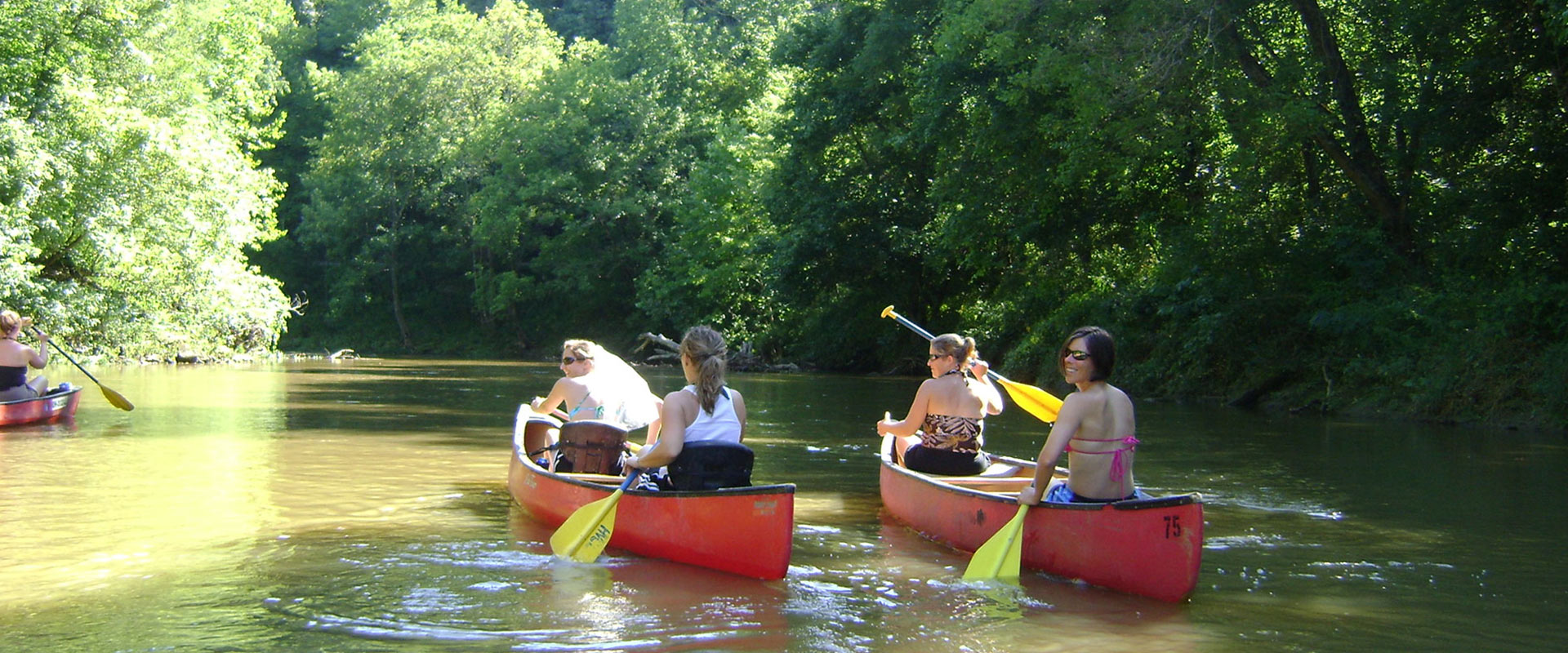Women in red canoes down the river.