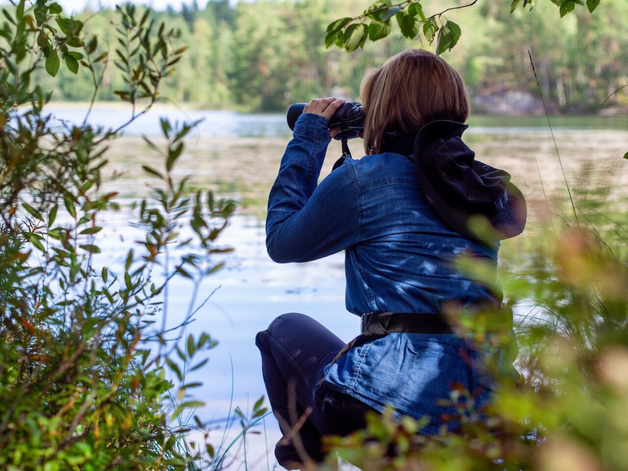 A woman birdwatching at Lake Logan State Park, one of the best things to do in Hocking Hills 